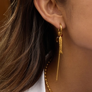 Gold stainless steel hoop earrings with fish tassel and agate stone worn by a model
