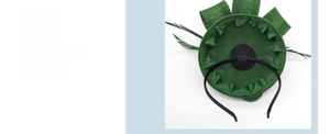 Detail view of dark green fascinator hat with feathers and mesh veil for weddings
