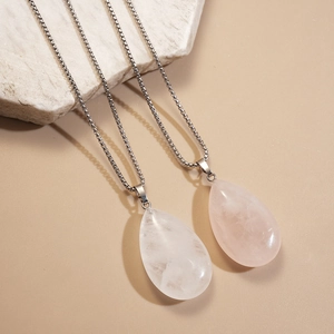 Detailed view of clear and pink stone teardrop pendants on silver chains