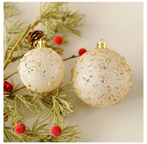 Detailed close-up of champagne gold Christmas ornaments with glitter and sequins on pine branches