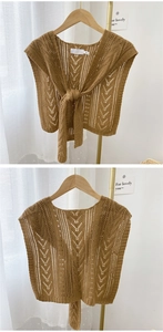 Detailed knit texture of brown hollow-out shawl with lace-up front and diamond patterns