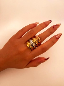 Macro detail of wide wavy multi-layered ring in gold and silver finish on hand