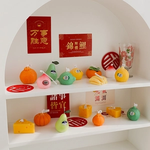 Creative fruit and cheese shaped scented candles displayed on a wooden shelf