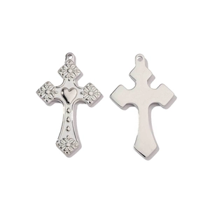 Detailed close-up of silver steel cross pendant with embossed floral and heart patterns