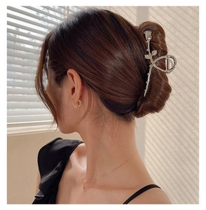 Pince à cheveux élégante en métal argenté motif rose sur un chignon à la française
