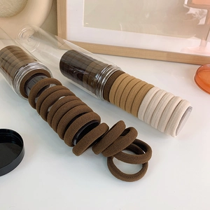 Elastic seamless hair ties in neutral earth tones with transparent storage containers