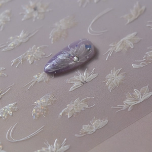 Laser nail art stickers with white floral patterns and glitter on a purple manicure