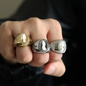 Close-up of vintage hiphop rings with Virgin Mary icons and cross embossing on men's hands