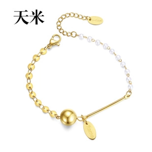 Detail of gold chain bracelet with white pearls and branded flame metal tag