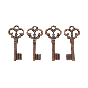 Detailed view of four vintage bronze key pendants with ornate hollow handles and aged texture