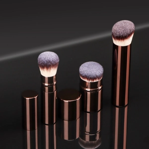 Detail view of four rose gold makeup brushes with purple gradient bristles and portable caps