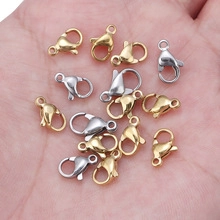 Detailed view of small gold and silver stainless steel lobster clasps on a palm for scale