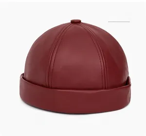 Detail view of a dark red faux leather docker cap with high-quality stitching