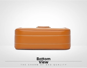 Detail view of the brown leather bag base featuring neat white decorative stitching
