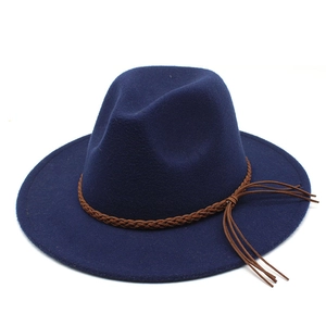 Detail of navy wool fedora hat featuring a brown braided leather band and side tassels