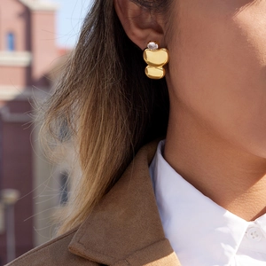 Elegant gold-plated geometric stud earrings with sparkling zircon on a female model