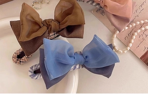 Nahaufnahme von geschichteten Haarklammern mit Schleife aus Mesh in Blau, Braun und Rosa