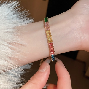 Gros plan du bracelet en zircone arc-en-ciel avec chaîne dorée ajustable au poignet