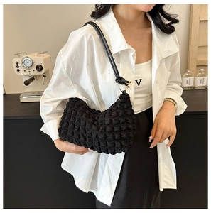 Detailed view of black bubble textured fabric on a stylish ruched cloud shoulder bag