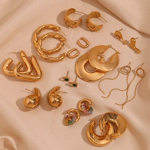 Detailed flat lay of assorted 18K gold-plated earrings on luxury champagne silk fabric