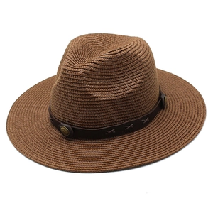 Détail d'un chapeau de paille avec bande en cuir synthétique et boucle métallique
