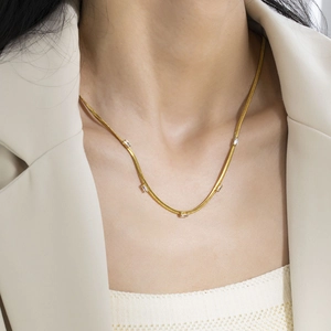 Close-up of elegant gold blade chain necklace with five rectangular cubic zirconia stones