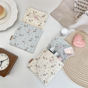 Flat lay of floral cotton storage pouches with snap button and vintage decor props