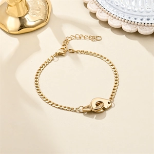 Detail of 18K gold plated stainless steel bracelet with handcuffs pendant and lobster clasp