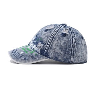 Distressed blue wash denim baseball cap with graffiti style green and white paint art