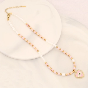 Collana di perline rosa con ciondolo a cuore malocchio su vassoio in ceramica