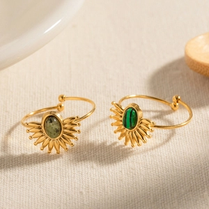 Detail of French vintage open rings with natural green stones and sunburst gold settings