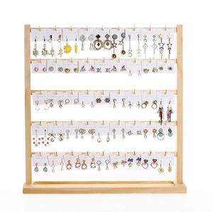 Five-tier wooden earring display stand organized with various stud and drop earrings