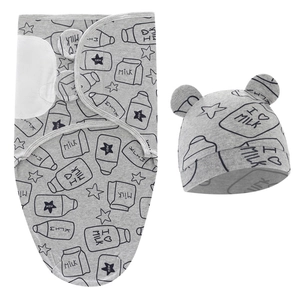 Detail showing grey newborn swaddle sack and matching hat with milk bottle and star print