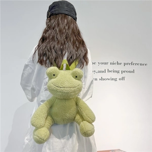 Cute green plush frog backpack with 3D eyes and limbs worn by a model on white background