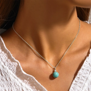 Close-up of s925 silver necklace with a turquoise sphere pendant and small diamond accent