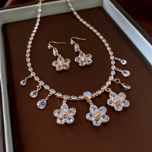 Detail view of vintage gold floral necklace and earrings set in a jewelry box