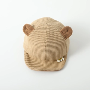 Detail of baby corduroy baseball cap with plush bear ears and stitched white woven label