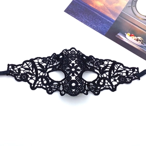 Detail of black lace mask with intricate floral patterns and silk ribbons for Halloween