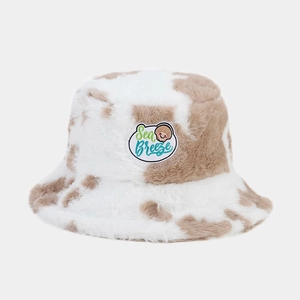 Detail of plush bucket hat featuring cow print pattern and Sea Breeze embroidered patch