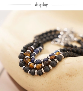 Macro view of multi-layer beaded bracelet with lava stone, tiger eye, and lapis lazuli