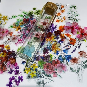 Detailed flat lay of watercolor floral PET stickers and a glass vial with cork stopper