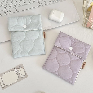 Close-up of quilted mini storage pouches in pastel blue and purple for daily essentials