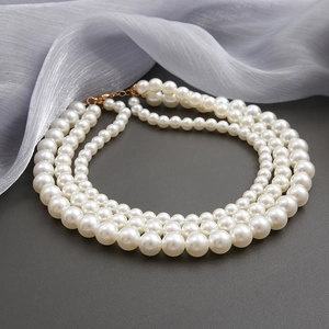 Elegant triple-layer pearl necklace with graduated white pearls and golden lobster clasp