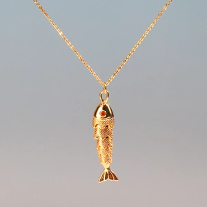 Detailed close-up of golden koi fish pendant with intricate scales and orange rhinestone eye