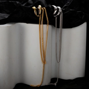 Detail of long metal chain ear cuffs in gold and silver with sparkling rhinestones