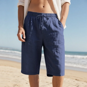 Men's navy linen shorts featuring a drawstring waist shown in a sunny beach setting