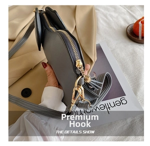 Close-up of golden metal hooks and fine texture on a grey elephant crossbody bag