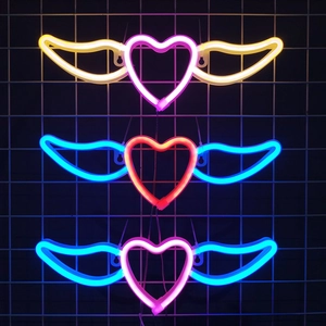 Néon LED cœur avec ailes en trois coloris sur un support en grille métallique noire