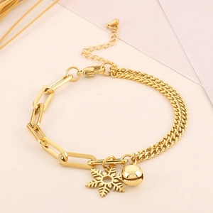 Detailaufnahme von 18K Gold-Schneeflocken und Glockenanhänger an einem doppelten Armband