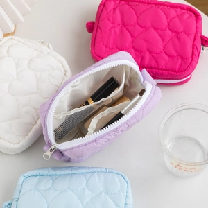 Close-up of heart quilted makeup bags with internal mesh pocket and zipper storage